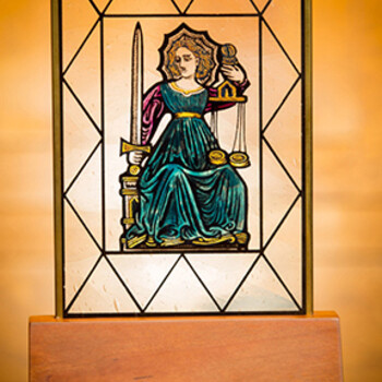 stained glass medallion resting in an oak base with a brass plaque
