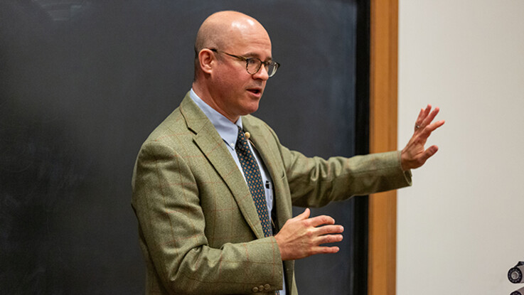 Orin Kerr speaks in front of a classroom gesturing with his left arm