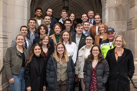 Dean Heather Gerken stands with a group of student veterans on the front steps of the law school